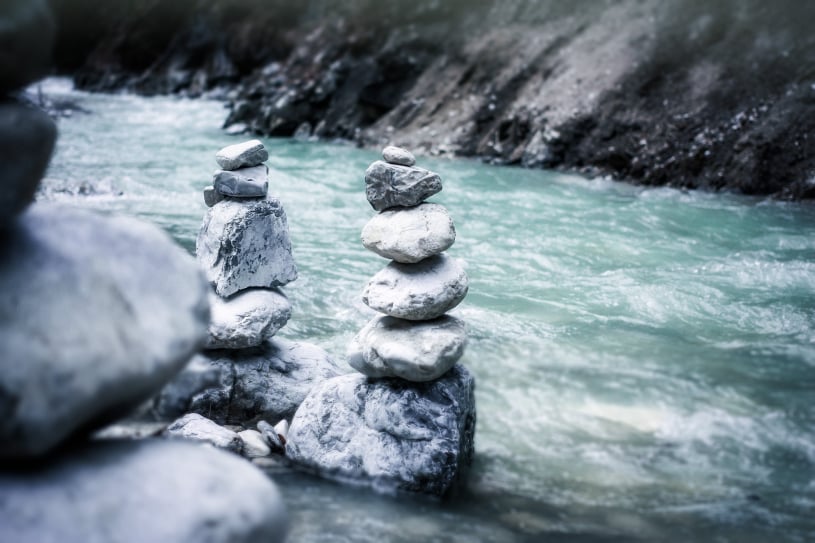 Balancing pebbles beside a stream